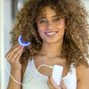 Frau mit Diamond Smile Power+ Phone Bleaching Mundstück LED Schiene in der Hand