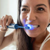 Frau mit Power LED Bleaching Schallzahnbürste von Diamond Smile in der Hand