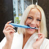 Frau mit Power LED Bleaching Schallzahnbürste von Diamond Smile im Mund im Bad