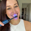 Frau mit Power LED Bleaching Schallzahnbürste von Diamond Smile in der Hand beim Zähneputzen