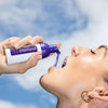 Frau mit Diamond Smile Lila Zahnbleaching Farbkorrektur Schaum in der Hand