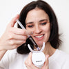Frau mit Diamond Smile Lila Zahnbleaching Gel - Farbkorrektur Zahnaufhellung Gel in der Hand