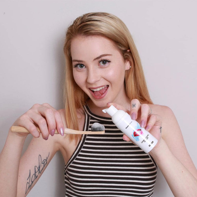 Frau mit Diamond Smile Zahnbleaching Schaum und einer Zahnbürste in der Hand