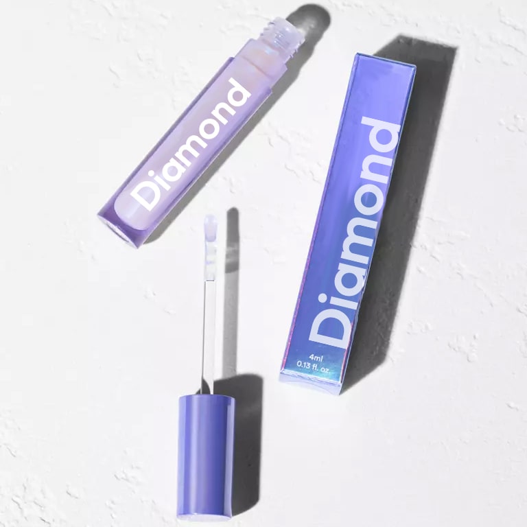 Kobieta nakłada sztyft Diamond Smile Bleaching Glow Stick na zęby w domu