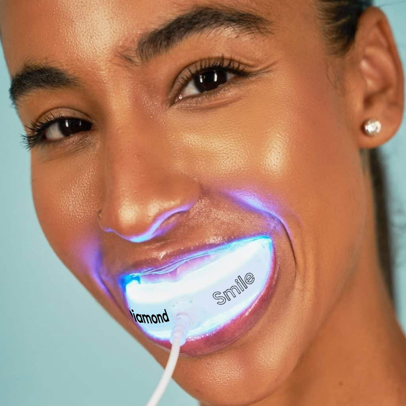 Kobieta wybiela zęby nakładką LED Diamond Smile, korzystając z telefonu, zabieg trwa 10 minut