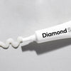 Zbliżenie uśmiechu z nakładką LED Diamond Smile podświetloną podczas wybielania zębów