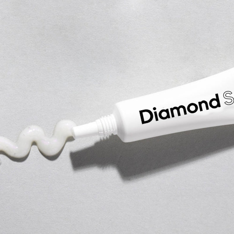 Zbliżenie uśmiechu z nakładką LED Diamond Smile podświetloną podczas wybielania zębów